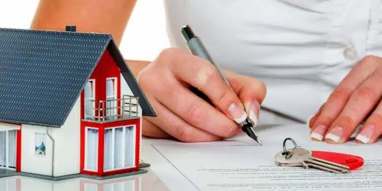 a woman signs a contract for a house with a real estate agent.